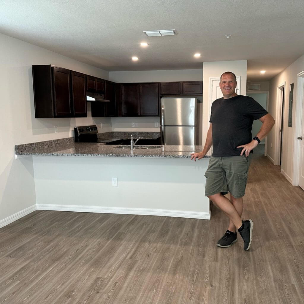 Grant Anderson of RealWealth stands in front of new kitchen on a property tour.